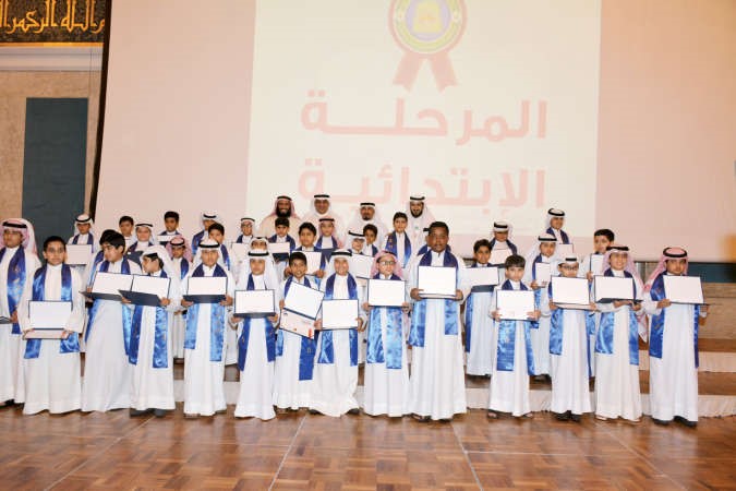 دمطر المطيري وسلمان المطيري يتوسطان الطلبة المكرمين خلال الحفل ريليش كومار ﻿