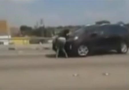 بالفيديو.. امراة حامل تتشبث بسيارة زوجها لمنعه من هجرانها