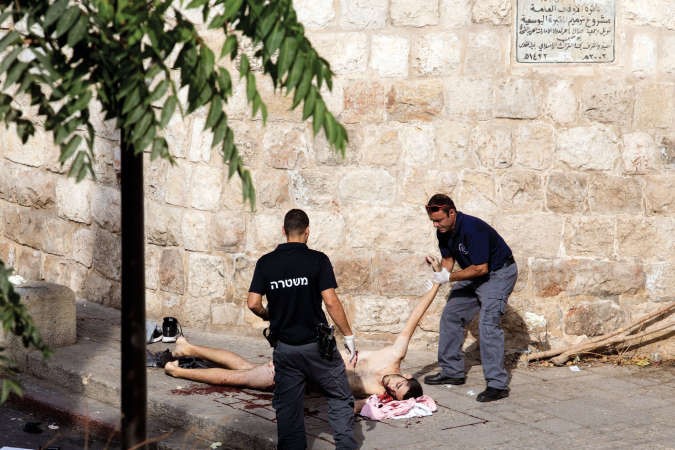 قوات الاحتلال تعاين جثة شاب اقدم على طعن عسكري امس وفي الاطار قريبات الطفل الفسطيني احمد شراكة يودعنه قبل تشييعهرويترز - افپ﻿