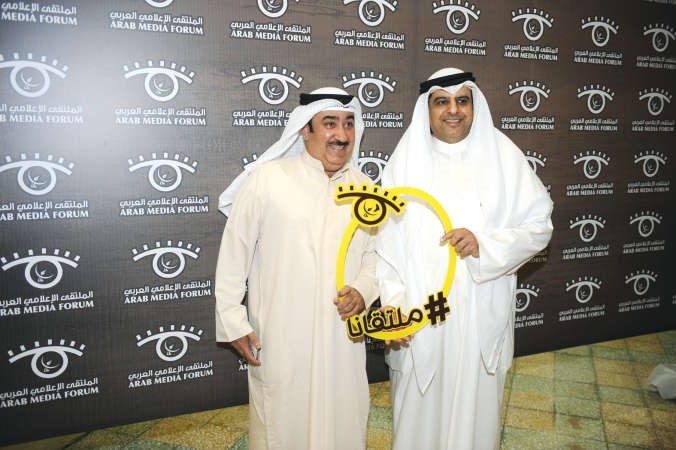 الزميلان سعد العلي وماضي الخميس يحملان شعار الملتقى الاعلامي﻿