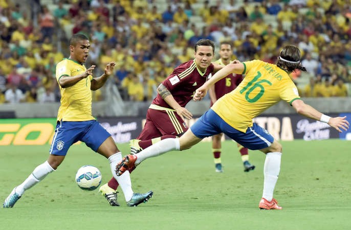 دوغلاس كوستا وفيليبي لويس في صراع على الكرة مع لاعب المنتخب الفنزويلي افپ
