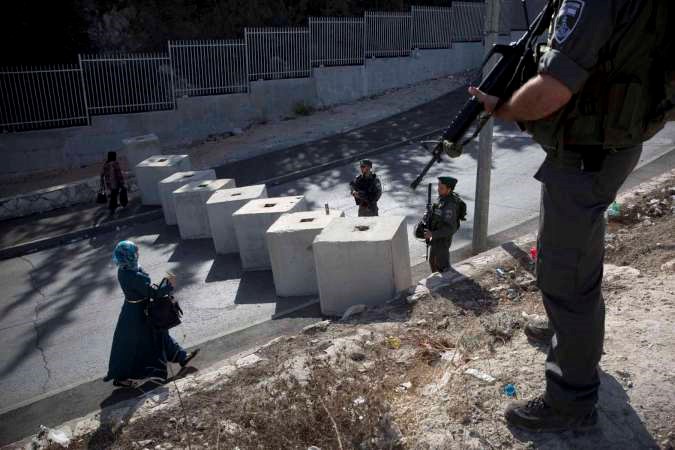 احد الحواجز الاسرائيلية لحرس الحدود يوقف فلسطينية في القدس المحتلة وفي الاطار جثة فلسطيني قتلته شرطة الاحتلال بعد طعنه اسرائيلية امس الاولاپ
