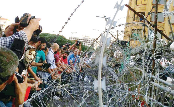 ناشطون من طلعت ريحتكم خلال تجمعهم امام الشريط الشائك الفاصل بين السرايا الحكومي و ساحة رياض الصلح احتجاجا على استمرار توقيف الناشطين وارف سليمان وبيار حشاش محمود الطويل
