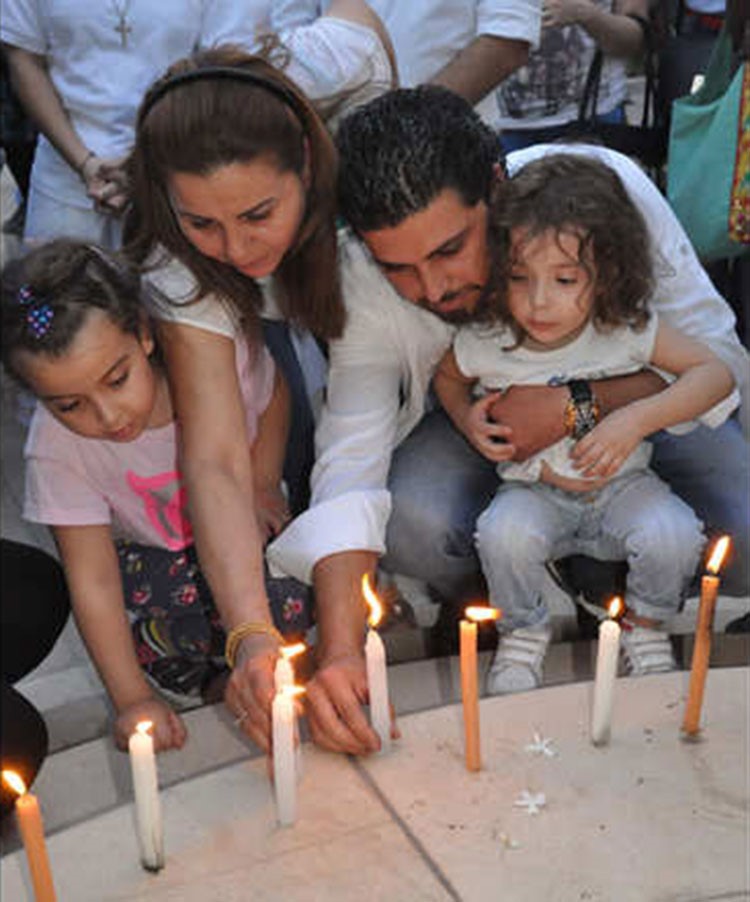 طفلي رندة مرعشلي جود وسيلينا يوقدان لها الشموع مع صديقي العائلة، في حدث خاص شهده المشفى الايطالي بدمشق مساء الاثنين 12 اكتوبر تشرين الاول، حيث صلى العشرات من محبي واصدقاء الممثلة السورية لشفائها