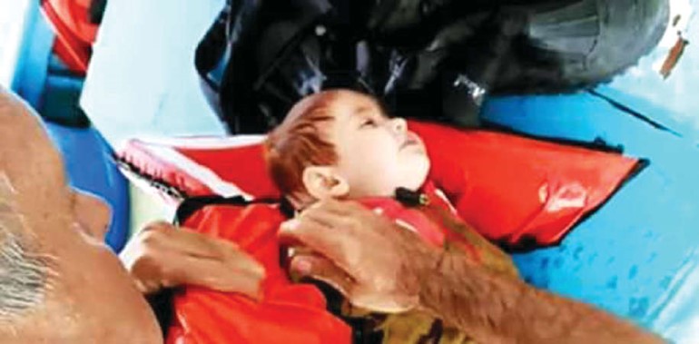 الصياد التركي ينزع سترة النجاة عن الطفل
