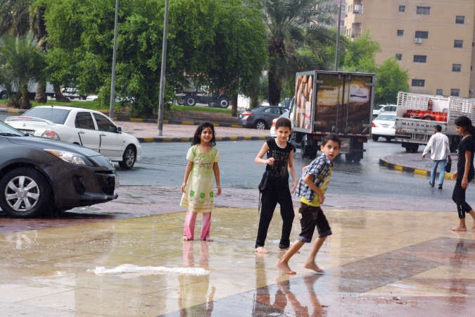 اطفال يلعبون في الشارع بعد نزول المطر﻿