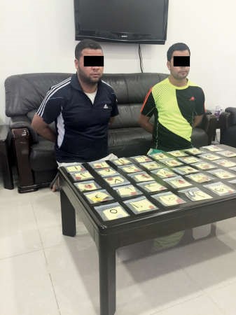 المتهمان بالتبصيم وامامهما البصمات﻿