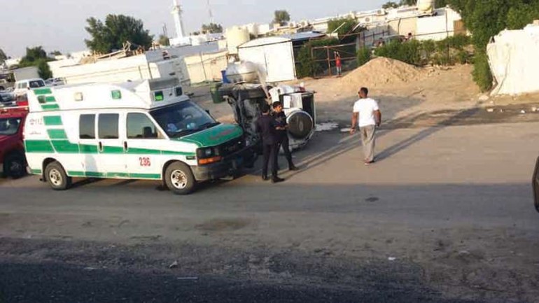 مركبة الحدث وقد انقلبت على جانبها وتبدو اليات الاطفاء والاسعاف في موقع الحادث﻿