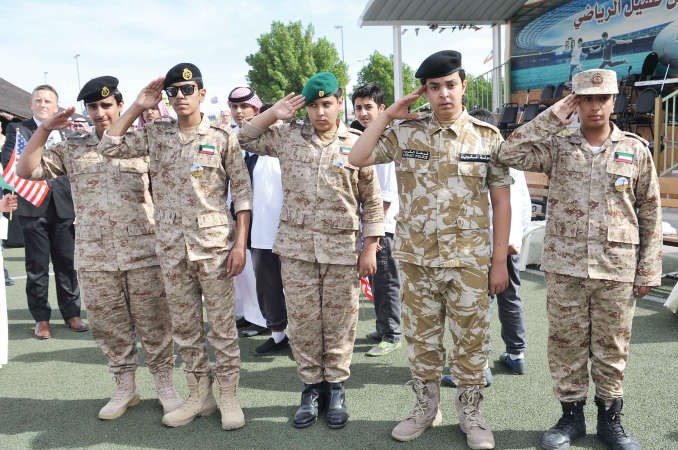 طلاب بالزي العسكري يؤدون التحية العسكرية ﻿