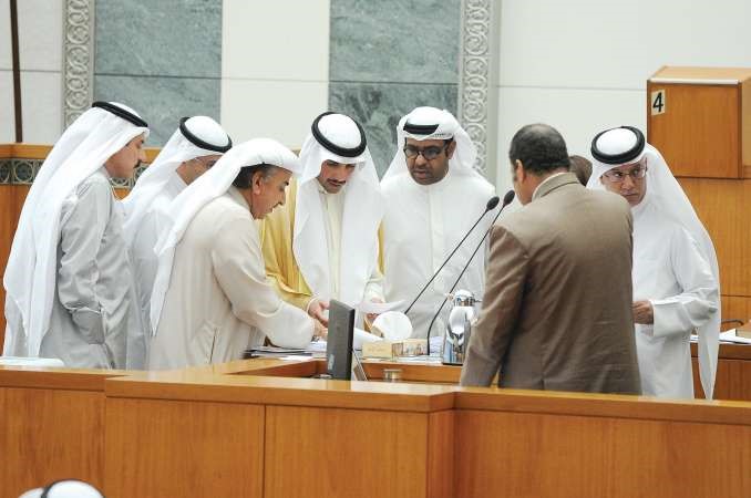 رئيس مجلس الامة مرزوق الغانم متوسطا النواب على المنصة لمتابعة مواد قانون الاحداث

