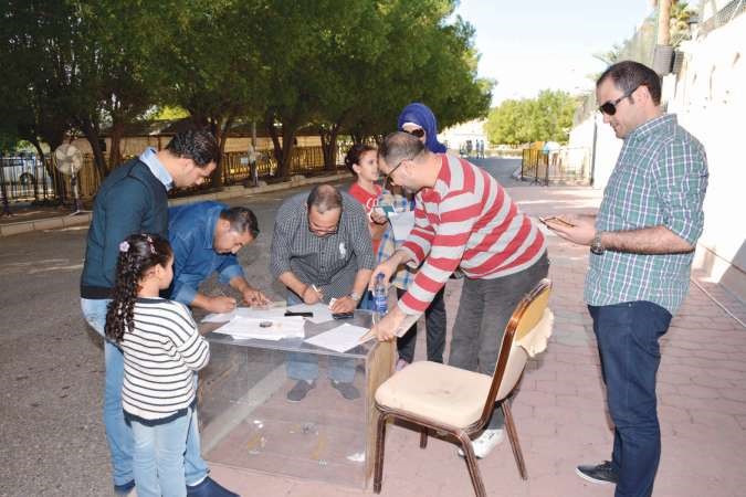 مجموعة من الناخبين خلال توقيع اقرار الاقامة في الكويت﻿