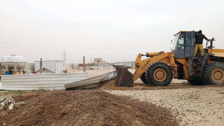 جرافات البلدية خلال ازالة الجواخير المخالفة 