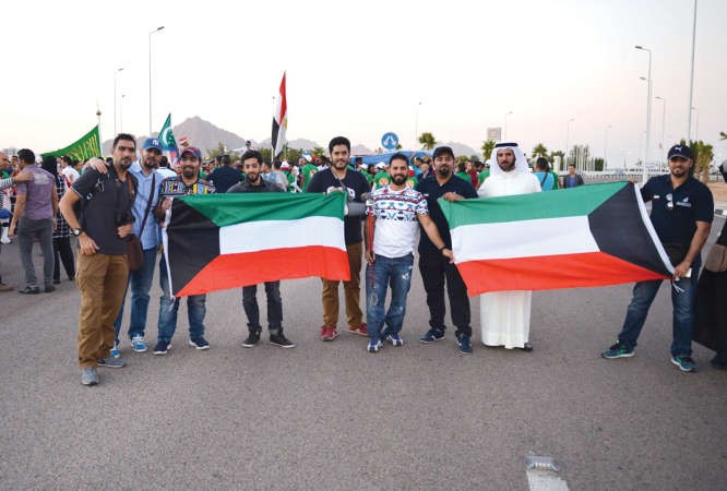 شباب يحملون علم الكويت في المهرجان ﻿