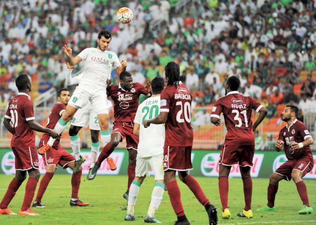 مهاجم الاهلي عمر السومة يتطاول للكرة وسط رقابة من مدافعي الفيصلي﻿