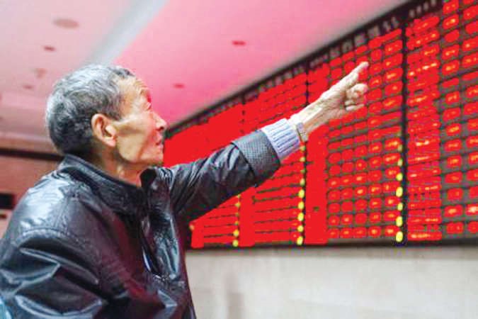 مستثمر يشير الى لوحة الكترونية تعرض خسائر الاسهم	رويترز﻿
