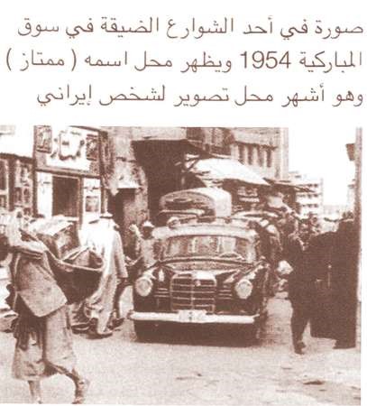 صورة في احد الشوارع الضيقة في سوق المباركية 1954 ويظهر محل اسمه ممتاز وهو اشهر محل تصوير شخصي ايراني﻿