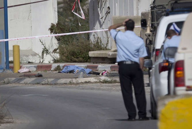 عناصر من شرطة الاحتلال يقفون قرب جثمان الشهيدة الفلسطينية مرام حسونة في طولكرم امس 	اب ﻿