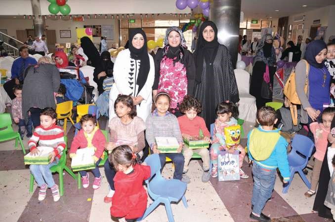 دضحية العنزي تتوسط فريق عمل مركز العصيمي الصحي خلال الاحتفال