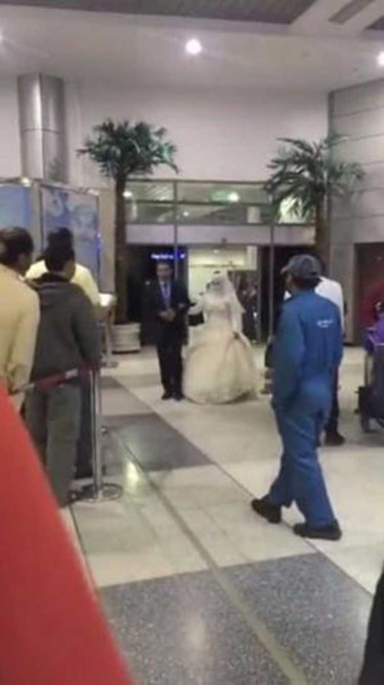 بالفيديو والصور.. عروس مصرية بفستان الزفاف تلفت أنظار المسافرين في مطار سعودي