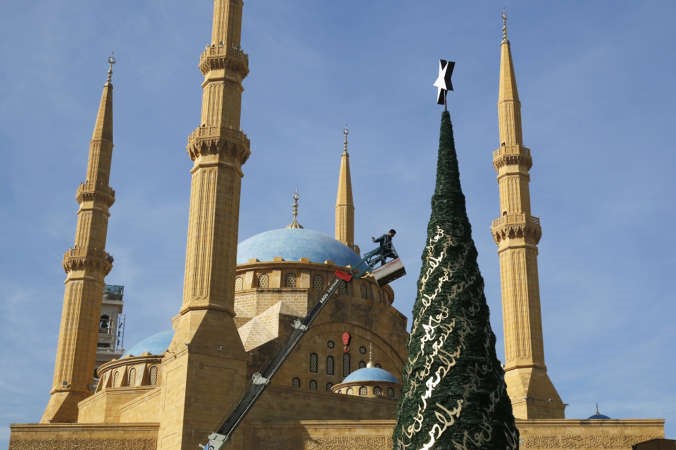 عامل يزين شجرة عيد الميلاد امام مسجد الامين في بيروت امس رويترز