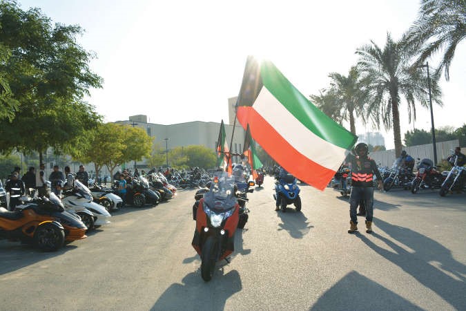 مشاركون يرفعون علم الكويت