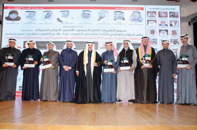 سمو الشيخ ناصر المحمد ويوسف الياسين يتوسطان ذوي المكرمين خلال المؤتمر ﻿