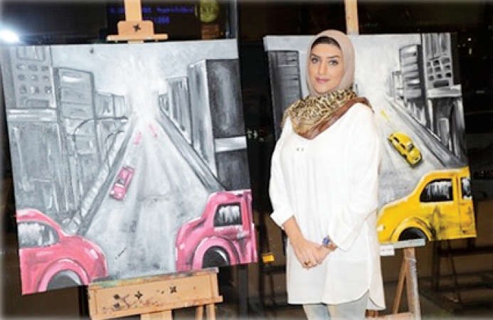 مشاركة امام احدى لوحاتها﻿