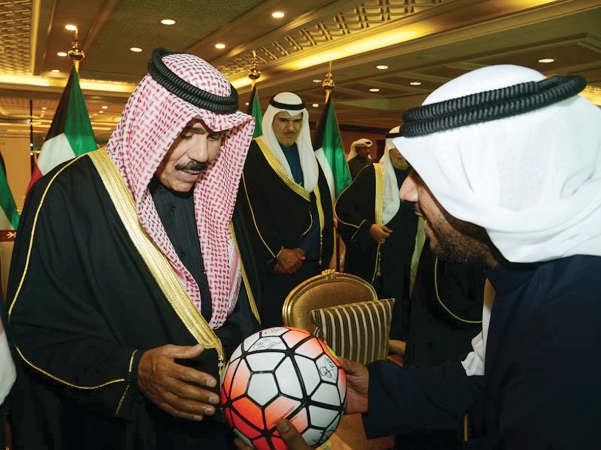 سمو ولي العهد الشيخ نواف الاحمد يهم بالتوقيع على كرة المباراة من الشيخ احمد المنصور﻿