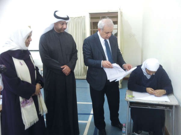 العيسى مدققا في اوراق اجابة احدى الطالبات خلال الجولة ﻿