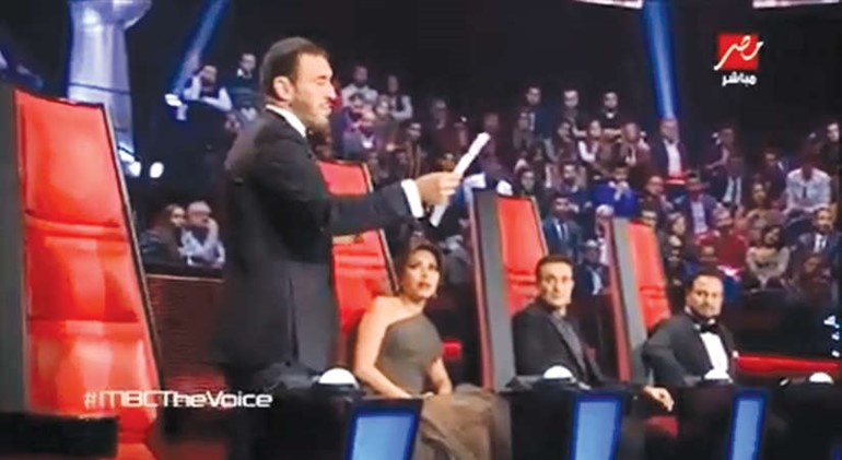 صورة تلفزيونية لكاظم وهو يقرا شعر الطفلة اللاجئة