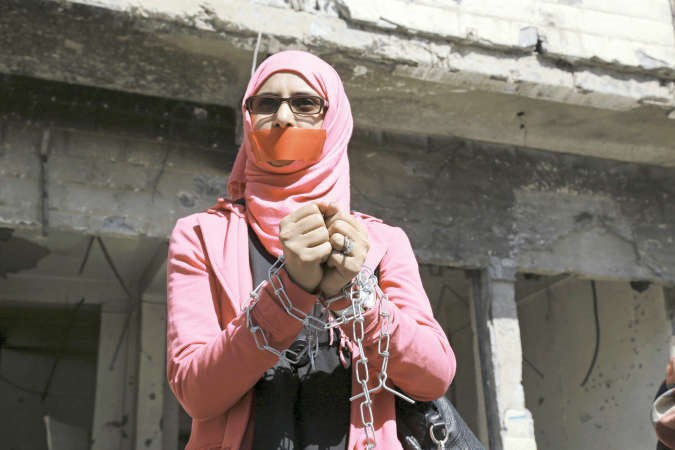 يمنية تبدو مكبلة اليدين ومغلقة الفم خلال مشاركتها في تظاهرة ضد حصار الحوثيين لمدينة تعزرويترز﻿
