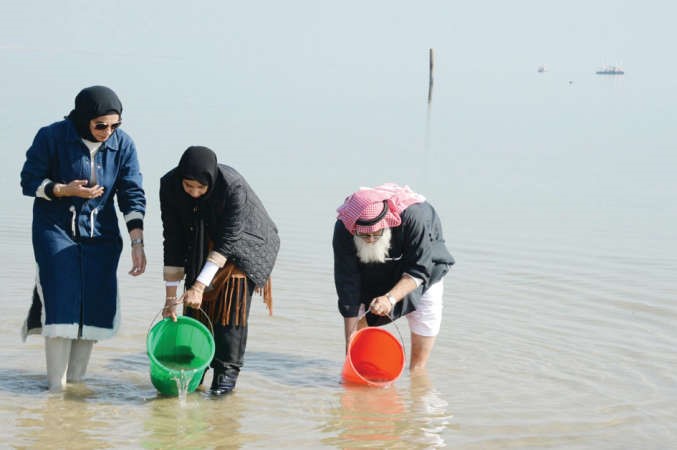 جانب من عملية اطلاق صغار الربيان في مياه جون الكويت﻿