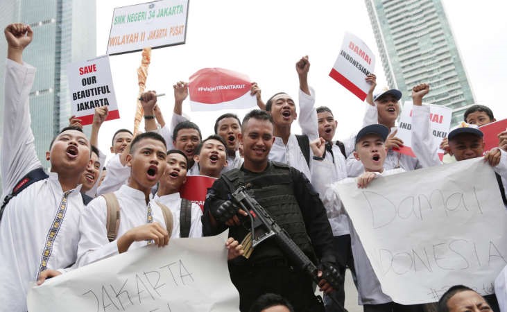 طلاب اندونيسيونفي صورة جماعية مع رجل شرطة خلال تظاهرة رافضة للارهاب غداة هجمات جاكرتا امس 	اپ ﻿