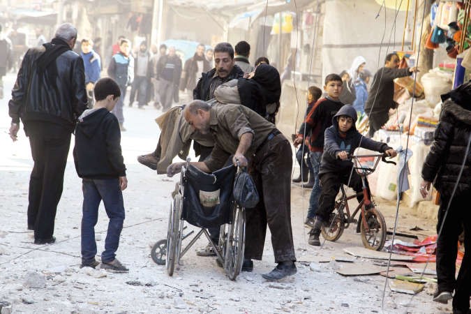 سوري يساعد امراة تضررت من غارة جوية في حي السكري في حلب امس الاولرويترز