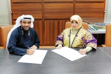 قيس العلي وباسمة الدهيم خلال توقيع العقد
