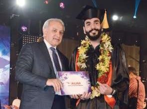 الوزير العيسى يسلم الشهادة لاحد الخريجين