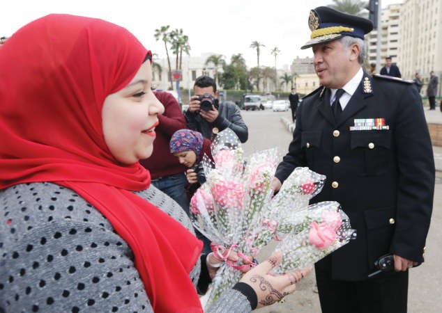 مواطنة تقوم بتوزيع الورود على افراد الشرطة في ميدان التحرير اپ