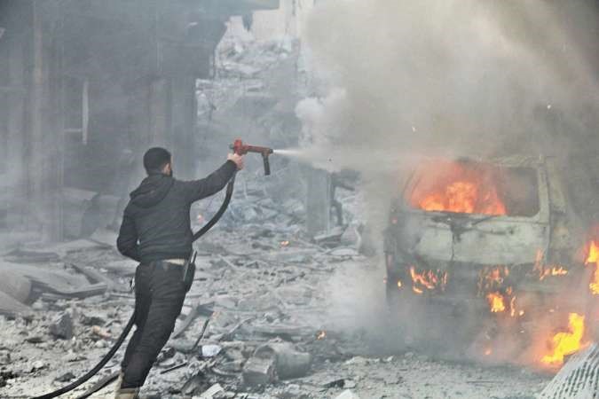 احد رجال الدفاع المدني يطفئ سيارة انفجرت في الهجوم في حي السكري بحلب امس 	انترنت﻿