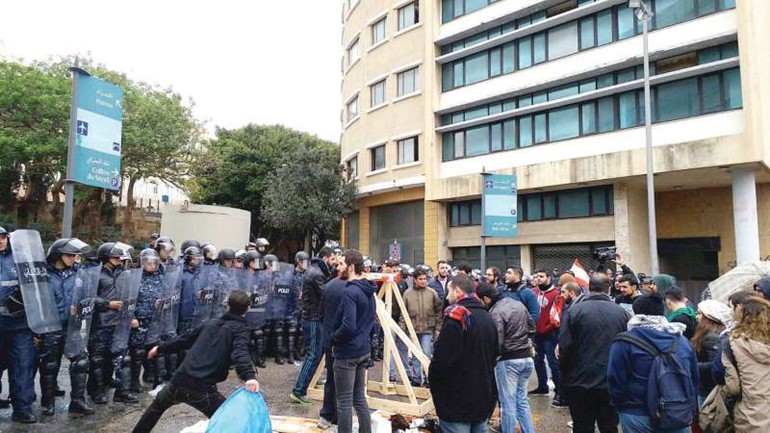 ناشطون لبنانيون يرمون اكياس الزبالة من فوق الحاجز الامني الذي شكلته قوى الامن امام السراي الحكومي امس محمود الطويل 