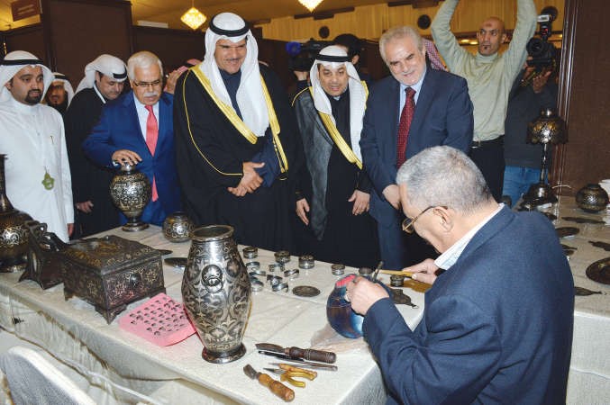متابعة لاحد الفنانين خلال اجرائه نقوشا اسلامية في احد الاعمال اليدوية