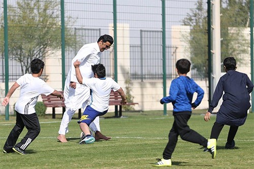 بالفيديو والصور .. أمير قطر الشيخ تميم يشارك الاطفال لعب كرة القدم بـ"الدشداشة"