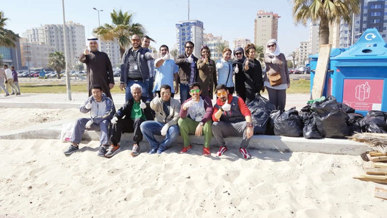 موظفو الشركة خلال حملة تنظيف الشاطئ﻿