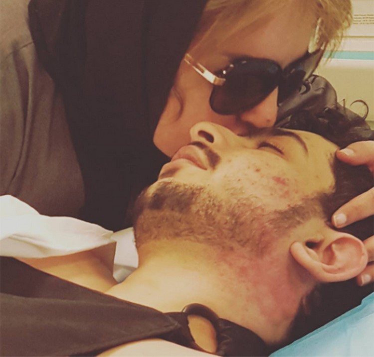 صورة: بدرية احمد بالحجاب تقبّل ابنها الشاب على سرير المرض وتطلب الدعاء له