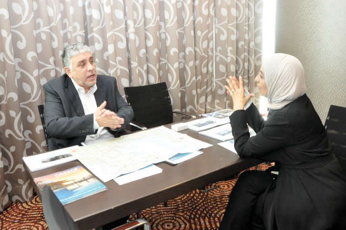 المدير العام لشركة ايكاروس جلف بنوس تزابسيدس يشرح لاحدى المهتمات بشراء عقار في اليونان﻿