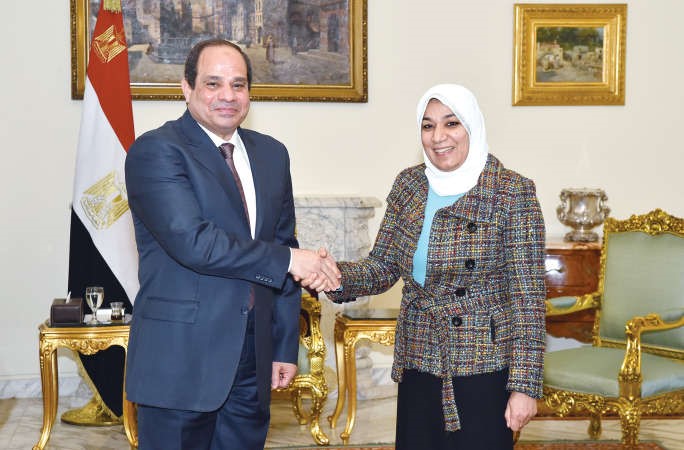الرئيس عبد الفتاح السيسي مصافحا مدير مكتب كونا بالقاهرة الزميلة منى ششتر