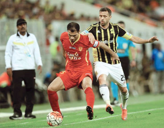 مهاجم الاتحاد سان مارتن يحاول انتزاع الكرة من لاعب القادسية