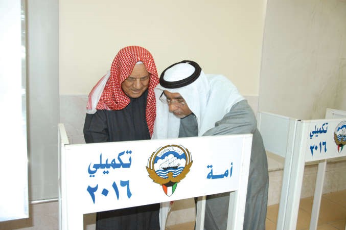 احد رؤساء اللجان يرشد احد كبار السن﻿
