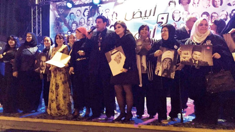 ابرار المفيدي حاملة صورة والدها في لقطة جماعية مع المكرمين في الاحتفال﻿