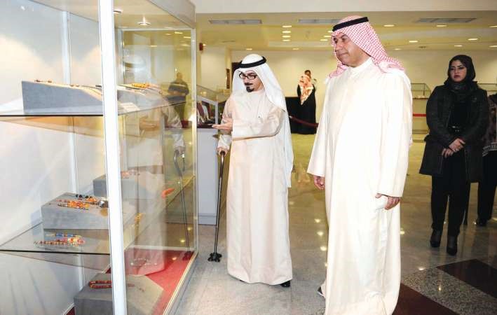 مدير ادارة الاثار والمتاحف التابعة للمجلس سلمان بولند خلال افتتاحه معرض المسابيح وبجانبه صاحب المعرض طلال الشطي 