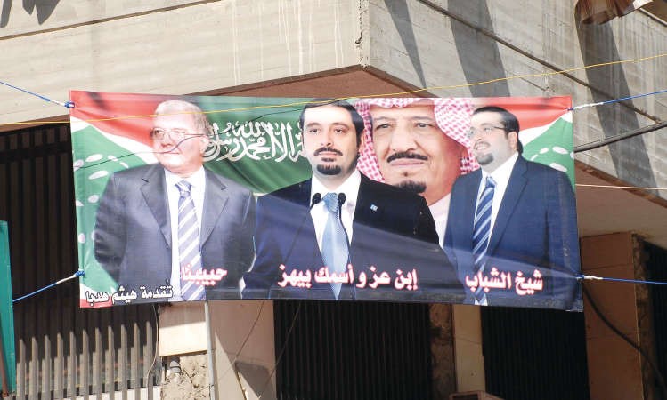 صورة مرفوعة في منطقة الطريق الجديدة تجمع خادم الحرمين الملك سلمان بن عبد العزيز والرئيس سعد الحريري ووزيرالداخلية نهاد المشنوق والامين العام لتيار المستقبل احمد الحريري محمود الطويل 